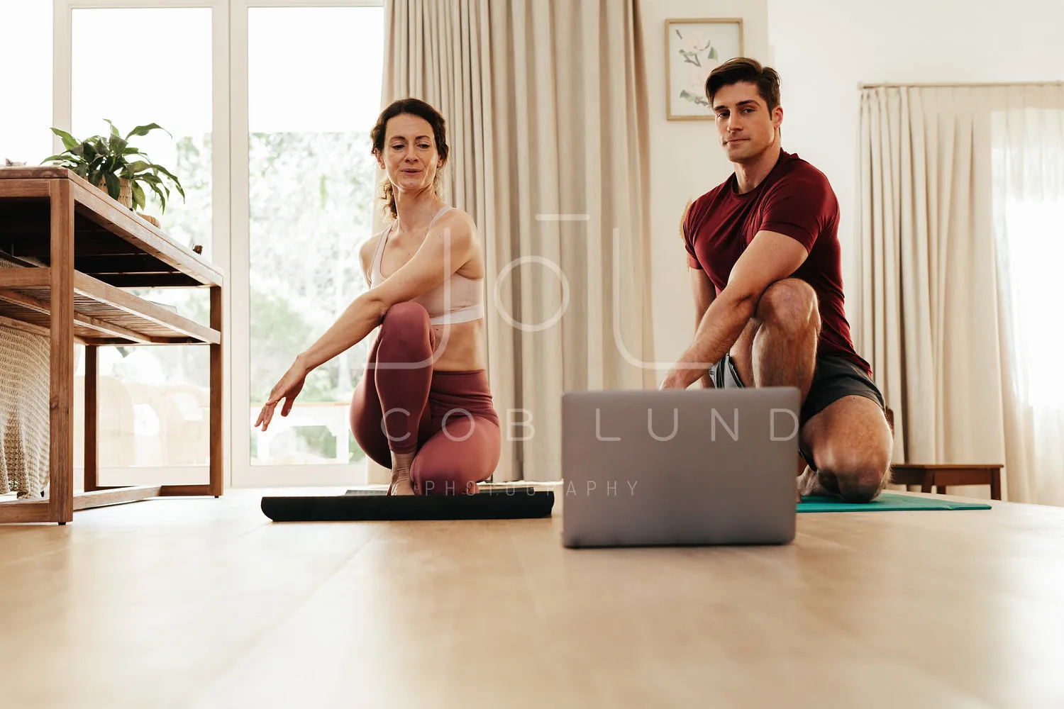 Couple going yoga watching fitness video on laptop
