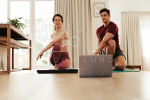 Couple going yoga watching fitness video on laptop